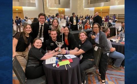 UNE Applied Exercise Science students gather at a table following their win at the American College of Sports Medicine National Quiz Bowl